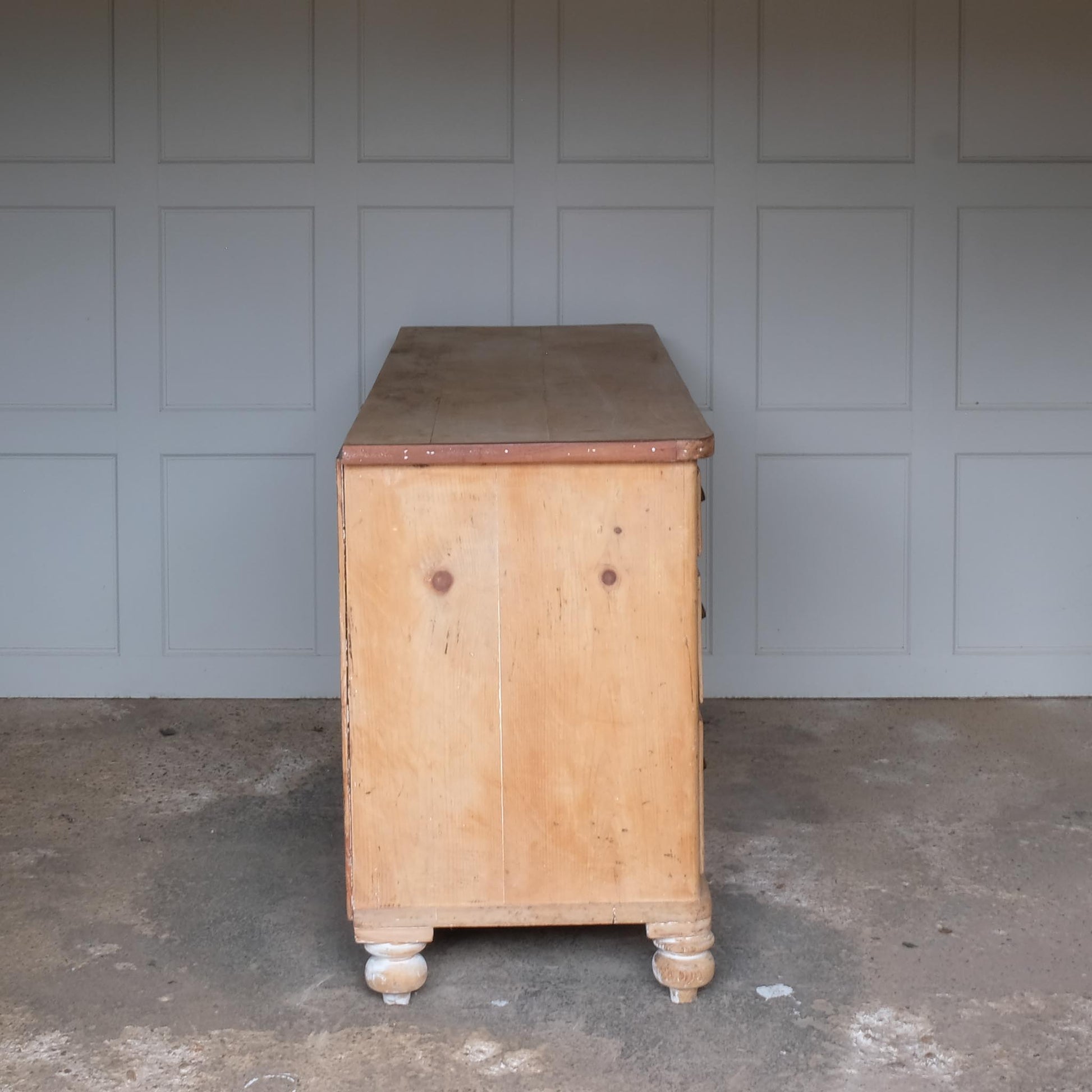 A large oak sideboard with, presumably late 19th / early 20th Century, comprising three drawers on each side with scallop cup handles, and a central drawer over a hinged cupboard door, raised on four turned bun feet. In very good, solid condition. Perfect for a kitchen or entrance hallway.