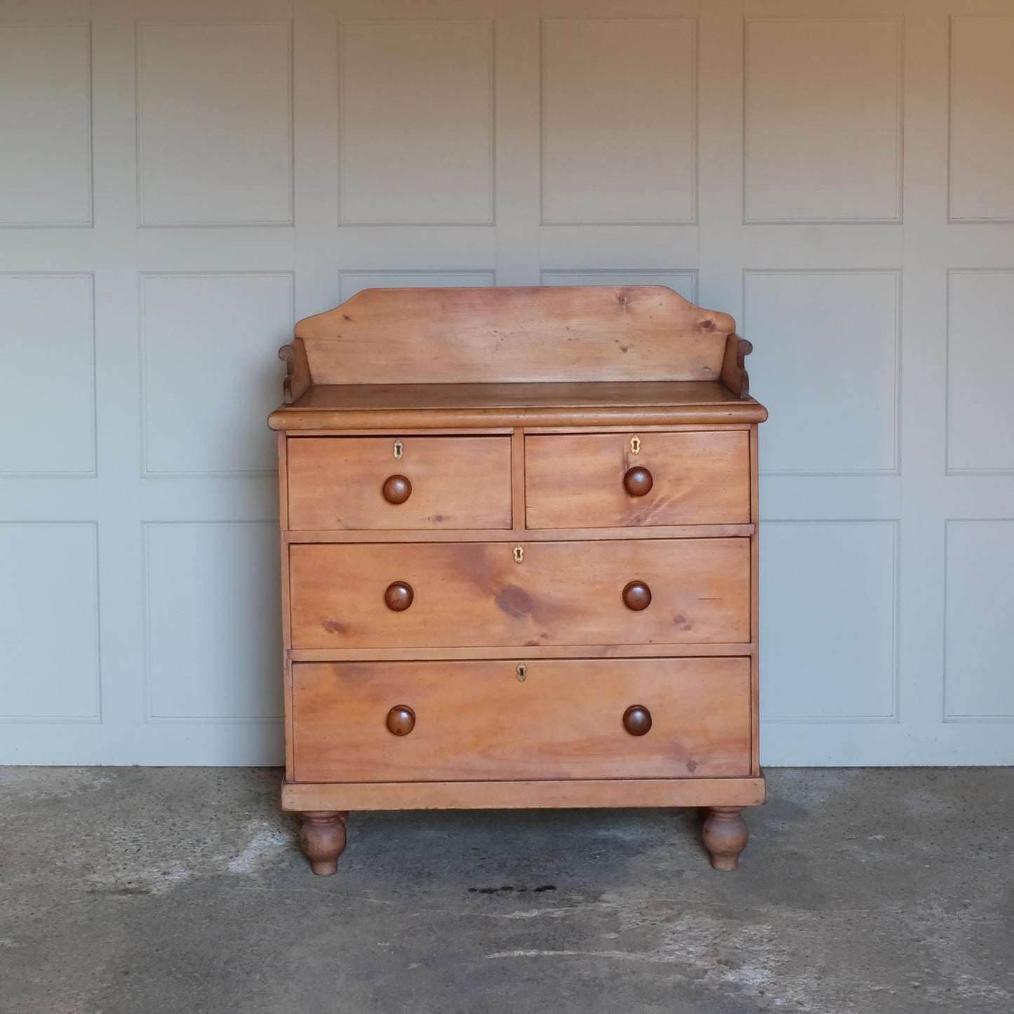 An Edwardian pine chest of drawers with 3/4 galleried top, with two short over two long drawers, raised on turned bun feet. Some gentle patina as to be expected, the drawers all working smoothly, in very good condition.