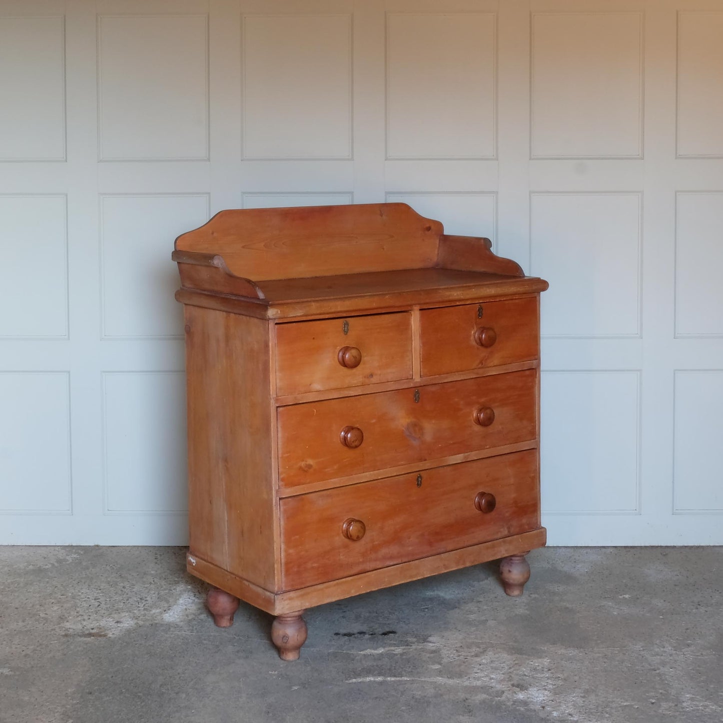 An Edwardian pine chest of drawers with 3/4 galleried top, with two short over two long drawers, raised on turned bun feet. Some gentle patina as to be expected, the drawers all working smoothly, in very good condition.