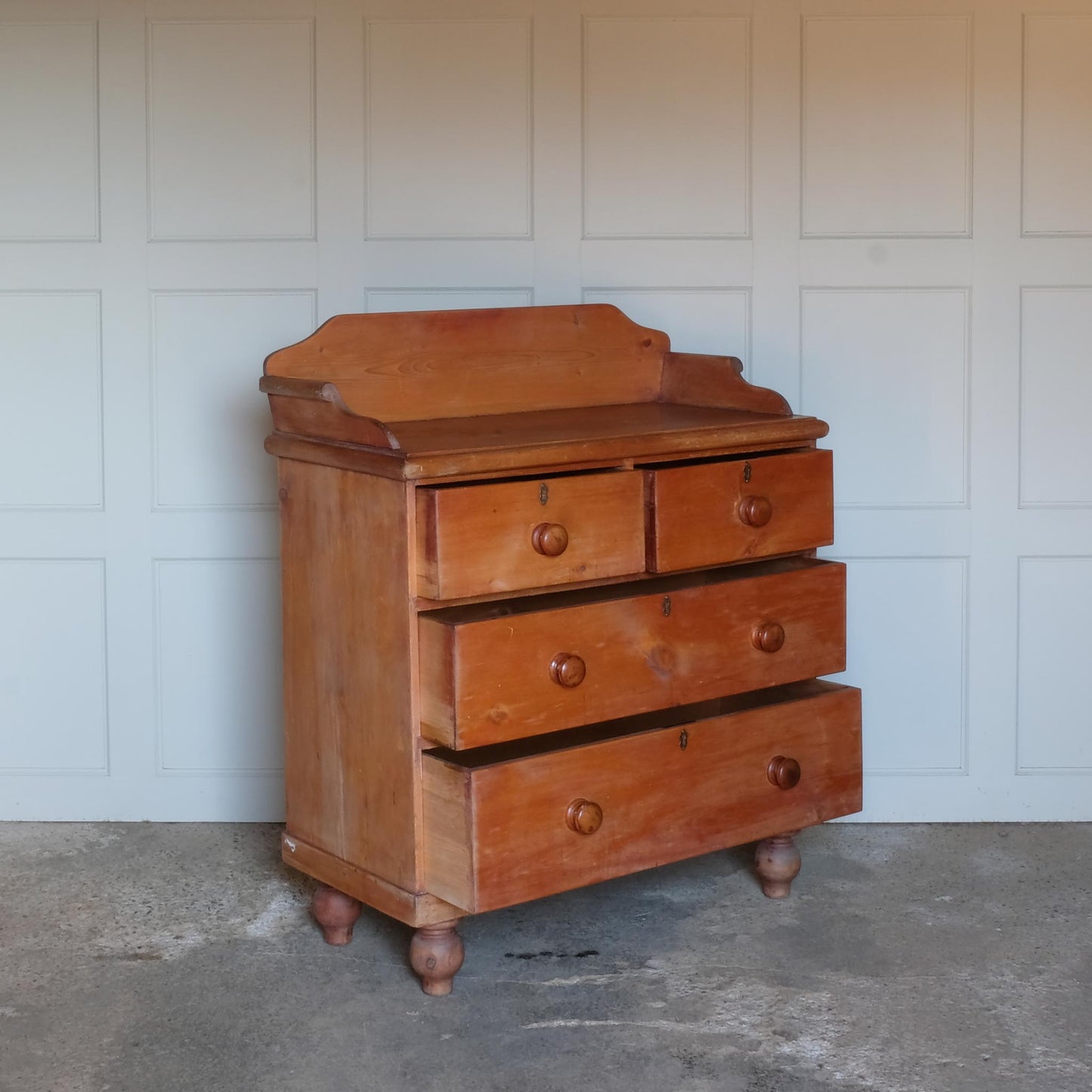 An Edwardian pine chest of drawers with 3/4 galleried top, with two short over two long drawers, raised on turned bun feet. Some gentle patina as to be expected, the drawers all working smoothly, in very good condition.