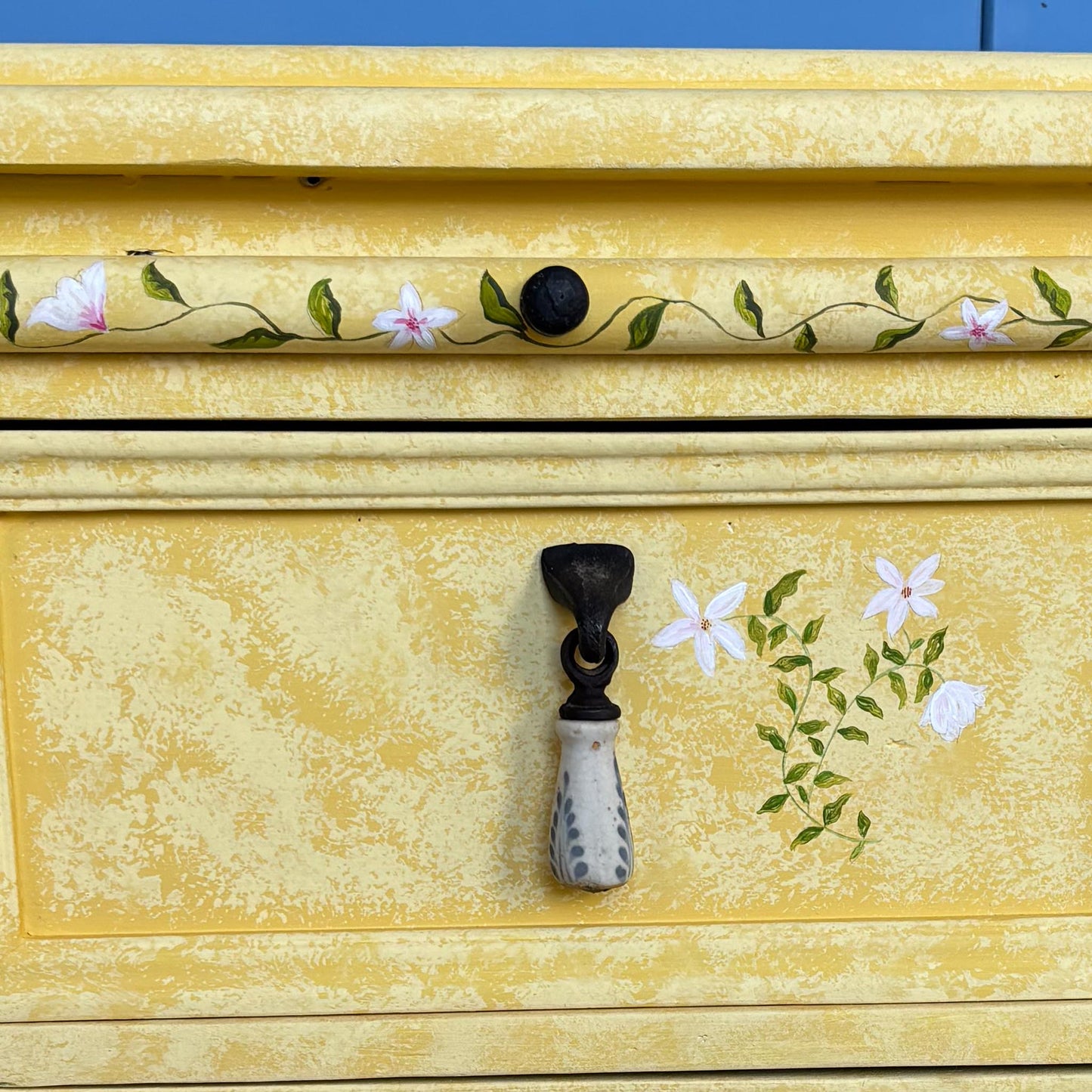 A stunning, unique matching pair of hand-painted chests of drawers, with brushing slides over three drawers. Finished in a fetching patinated yellow and decorated with exotic animals and Flora, in very good condition. Ideal for a children's bedroom or to liven up a sitting room. A unique pair in collaboration with Bunny Howe.