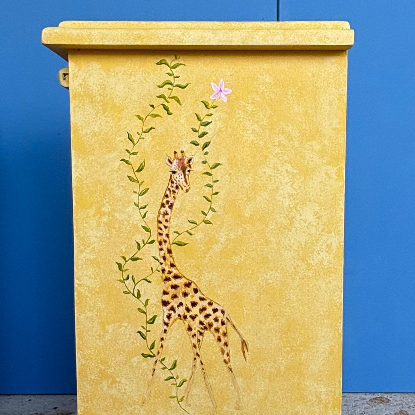 A stunning, unique matching pair of hand-painted chests of drawers, with brushing slides over three drawers. Finished in a fetching patinated yellow and decorated with exotic animals and Flora, in very good condition. Ideal for a children's bedroom or to liven up a sitting room. A unique pair in collaboration with Bunny Howe.