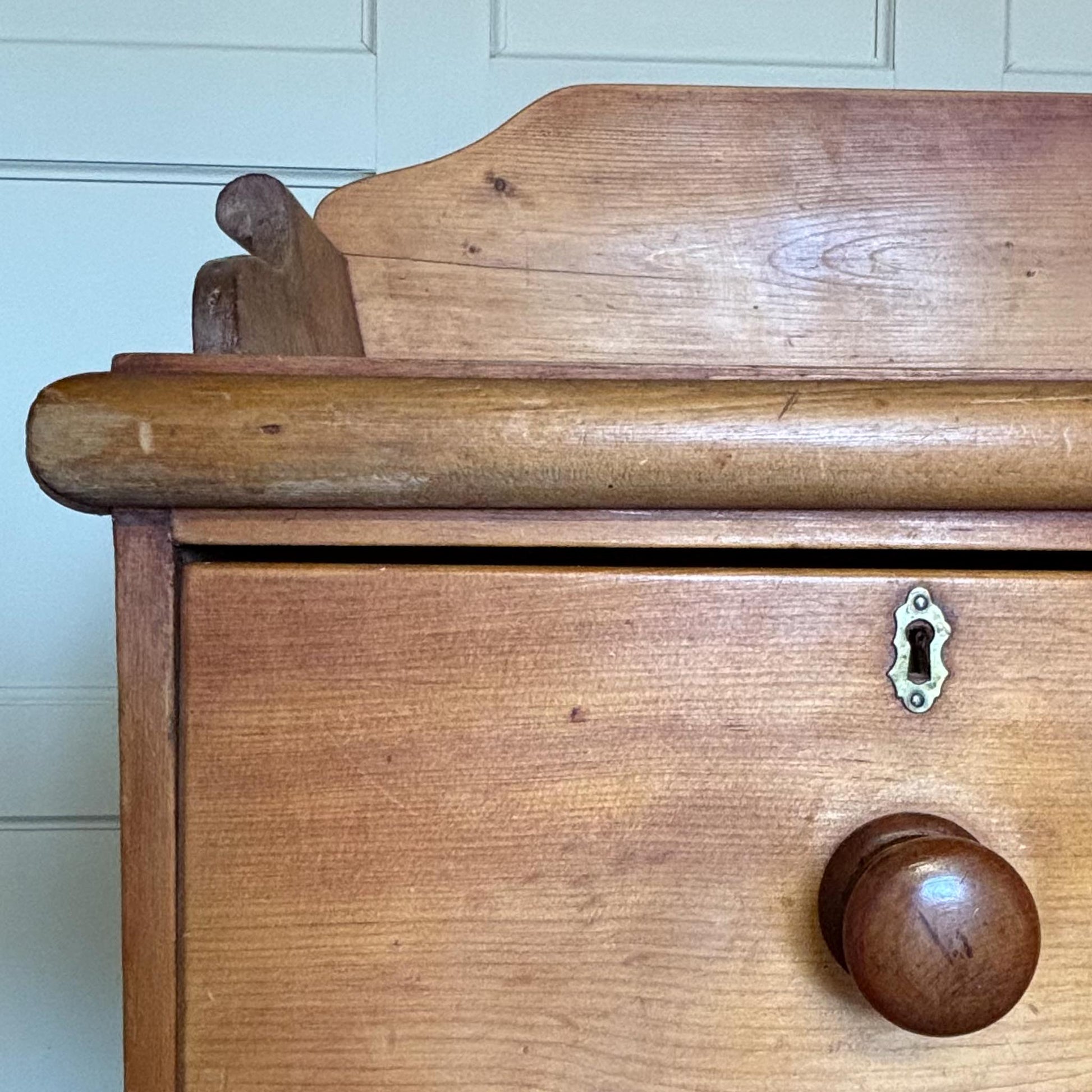 An Edwardian pine chest of drawers with 3/4 galleried top, with two short over two long drawers, raised on turned bun feet. Some gentle patina as to be expected, the drawers all working smoothly, in very good condition.