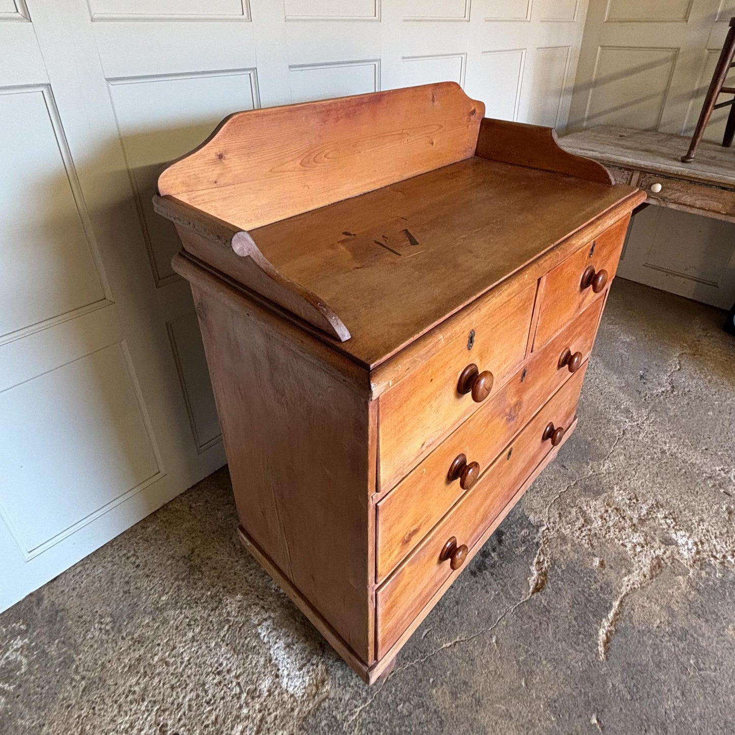 An Edwardian pine chest of drawers with 3/4 galleried top, with two short over two long drawers, raised on turned bun feet. Some gentle patina as to be expected, the drawers all working smoothly, in very good condition.