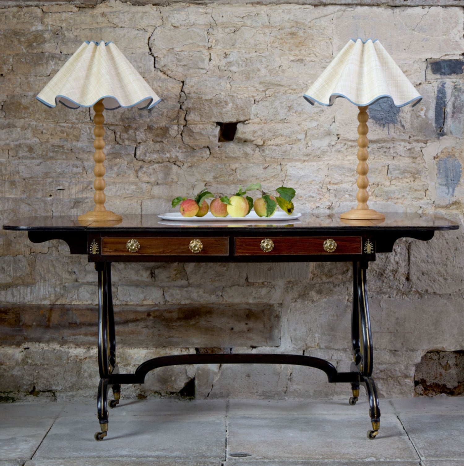 A beautiful and rare Regency rosewood and ebonised sofa table, circa 1820, elegant crossbanding on the top, with two frieze drawers and matching faux drawers to the reverse. Raised on beautiful, ebonised and gilded lyre end supports with a distinctively arched stretcher, on brass castors. A restored scratch to the surface, undertaken by Anthony Beech, in very good condition.